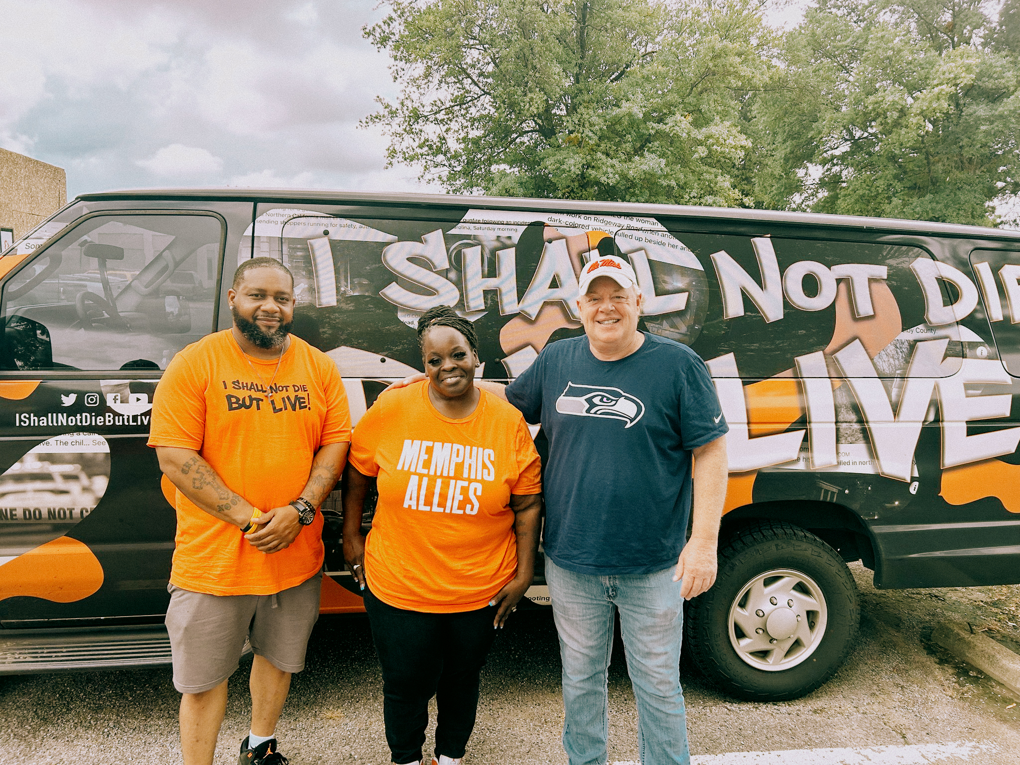 Three Memphis Allies volunteers smiling in front of a service van