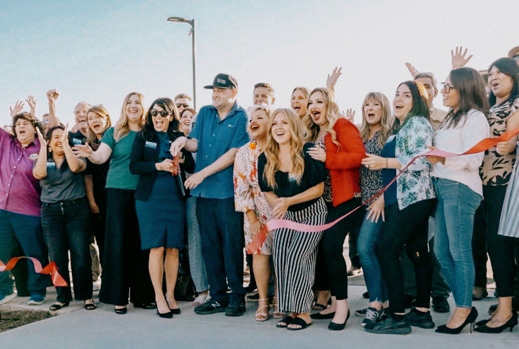 Group celebrating with a Service Concierge ribbon-cutting