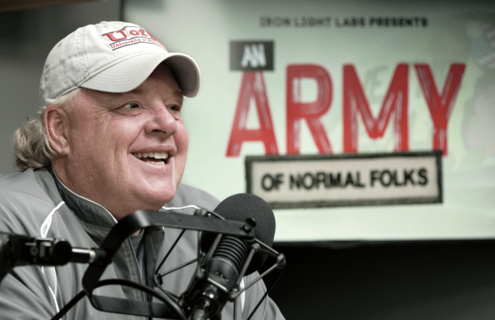 Coach Bill Courtney at the microphone in front of an Army of Normal Folks banner